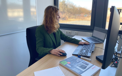 Junge Frau am Schreibtisch bei Glen Dimplex Deutschland GmbH macht eine Ausbildung